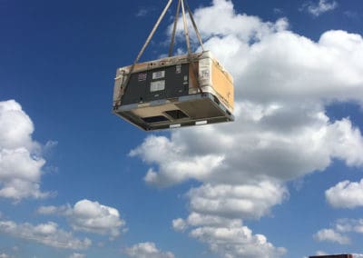 Crane lifting a large HVAC unit